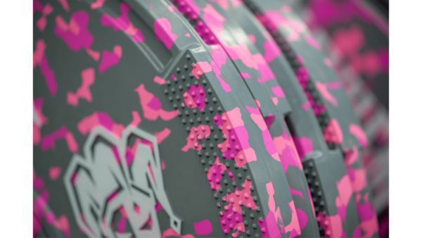 Colorful neon fleck bumper plates stacked for workout at a gym