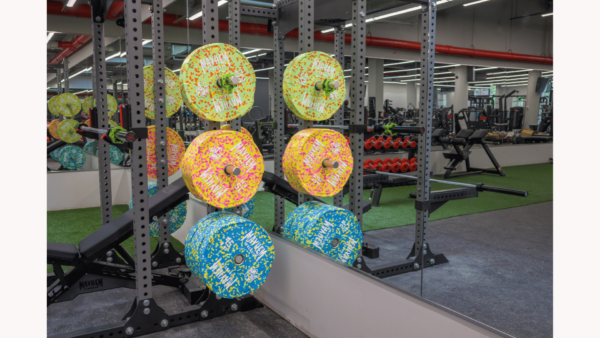 Colorful neon fleck bumper plates stacked for workout at a gym